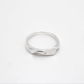 Silver ring with a diamond on a white background, close up top down view